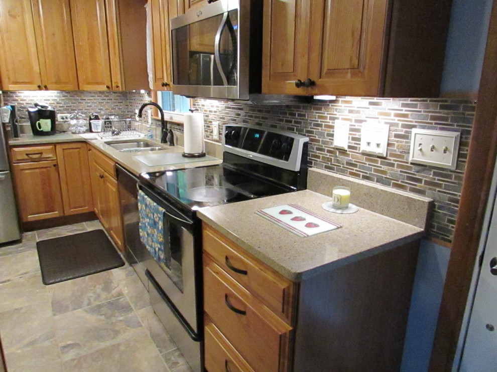 Home design - mid-sized transitional l-shaped ceramic tile home design idea with a double-bowl sink, raised-panel cabinets, light wood cabinets, quartz countertops, multicolored backsplash, mosaic tile backsplash, stainless steel appliances and an island