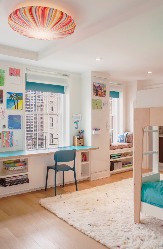 New York City Combination-Renovatin - A colorful, fun kid's bedroom.  A gorgeous fabric surface mounted light sets the tone.  Custom built blue laminate work surface, bookshelves and a window seat.  Blue accented window treatments.  A colorful area rug with a rainbow of accents.  Simple clean design.  A column with a glass magnetic board is the final touch.