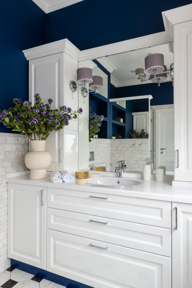 Design ideas for a mid-sized transitional 3/4 bathroom in Other with raised-panel cabinets, white cabinets, gray tile, blue walls, an undermount sink, multi-coloured floor, white benchtops, a single vanity and a built-in vanity.