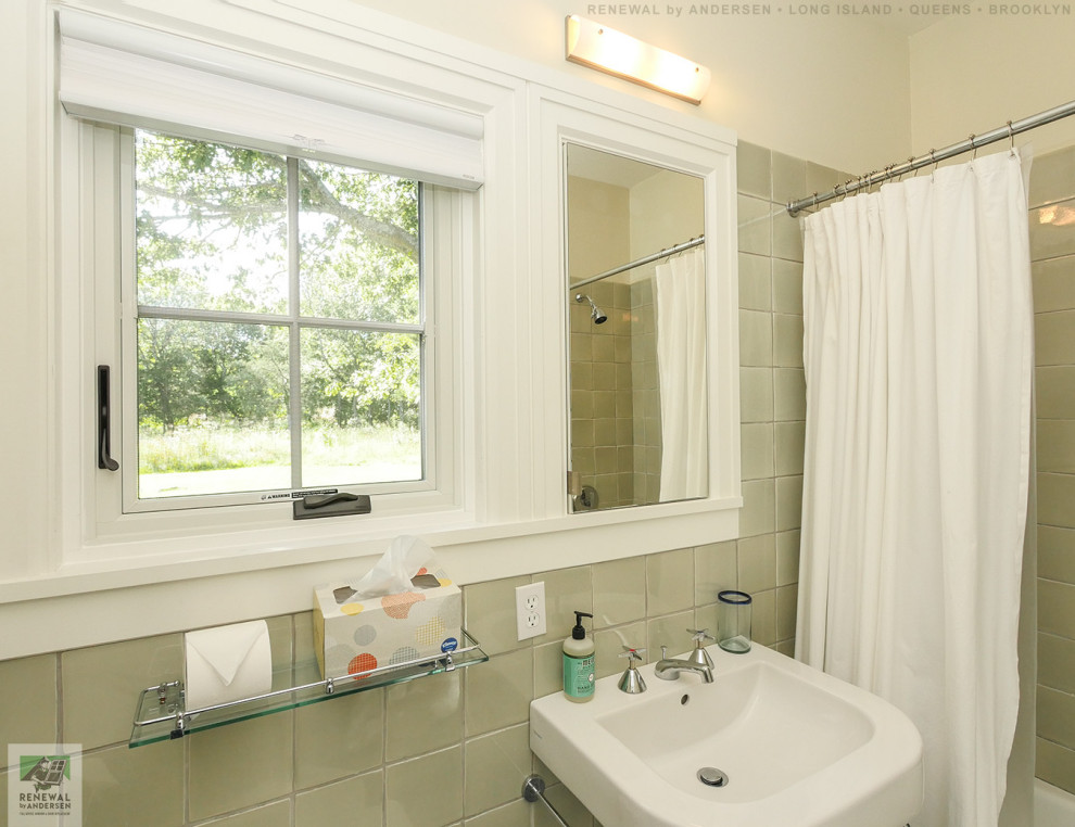 ニューヨークにある中くらいなおしゃれな浴室 (オープンシェルフ、白いキャビネット、アルコーブ型浴槽、シャワー付き浴槽	、分離型トイレ、緑のタイル、セラミックタイル、黄色い壁、セラミックタイルの床、ペデスタルシンク、シャワーカーテン、白い洗面カウンター、洗面台1つ、フローティング洗面台、三角天井) の写真