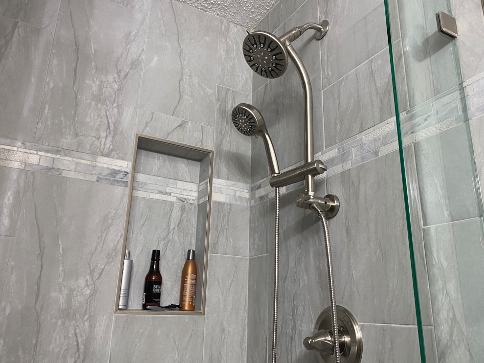 Exemple d'une petite douche en alcôve chic avec un carrelage gris, des carreaux de porcelaine, un mur gris, une cabine de douche à porte battante et une niche.