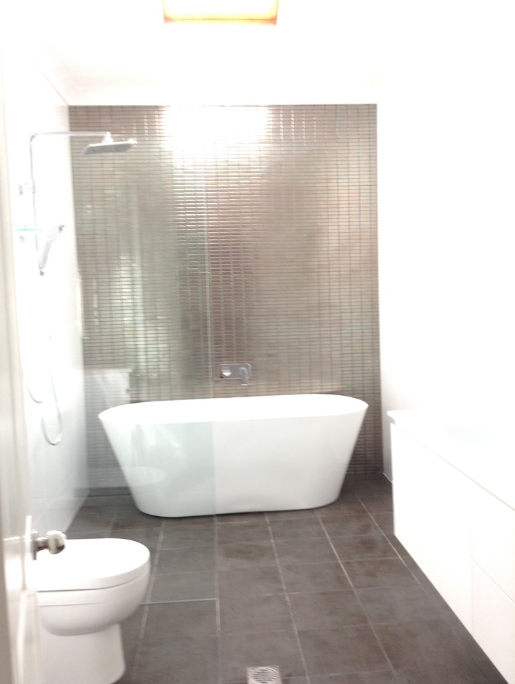 Example of a mid-sized minimalist master brown tile and ceramic tile ceramic tile bathroom design in Sydney with an integrated sink, flat-panel cabinets, white cabinets and glass countertops