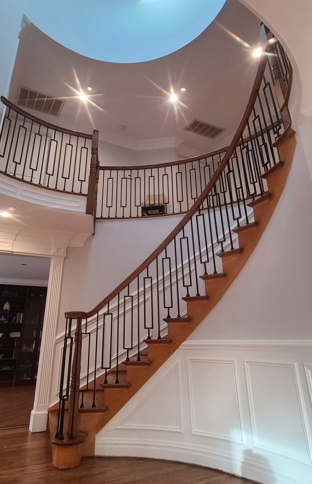 Design ideas for a large contemporary wood curved mixed railing staircase in Philadelphia with wood risers.