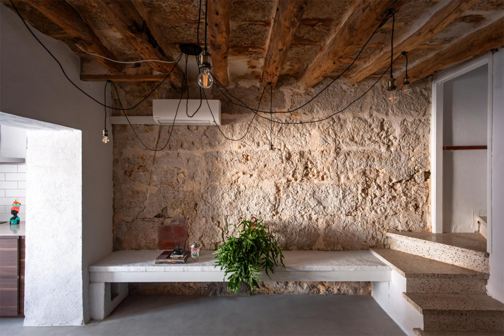 Diseño de sala de estar con biblioteca tipo loft urbana de tamaño medio con paredes blancas, suelo de madera oscura y vigas vistas