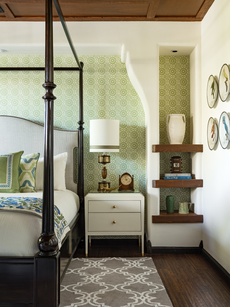 This is an example of a mediterranean bedroom in Los Angeles with green walls, dark hardwood floors and brown floor.