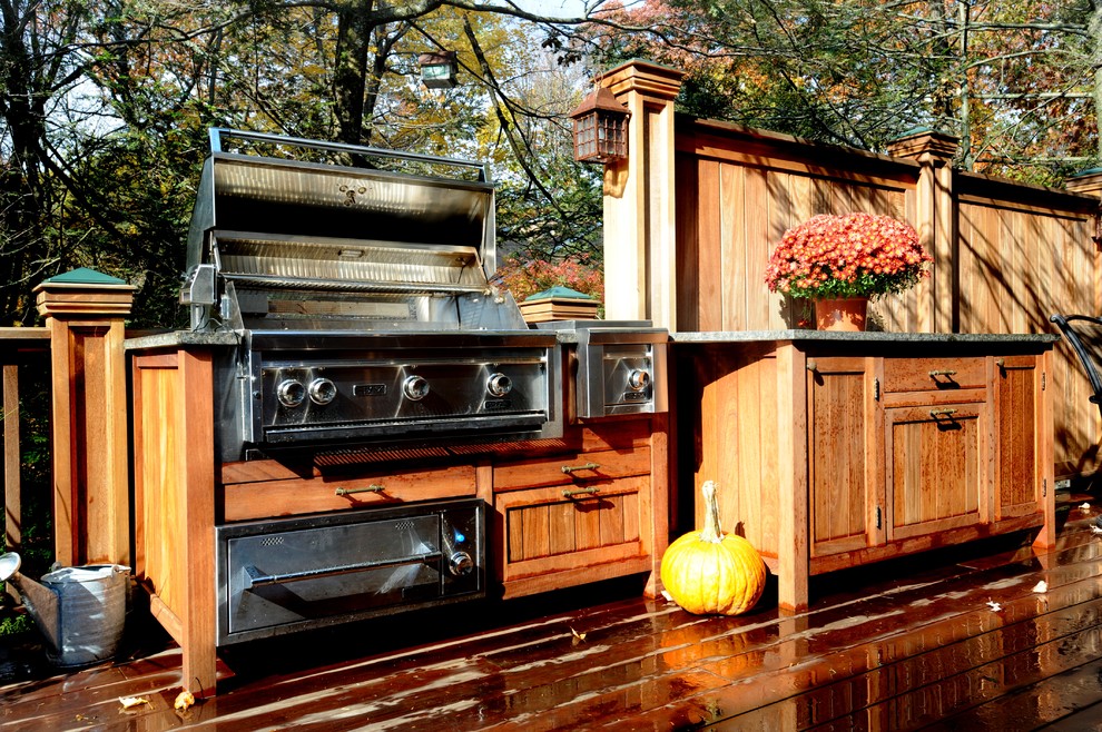 This is an example of a country backyard deck in New York with an outdoor kitchen.