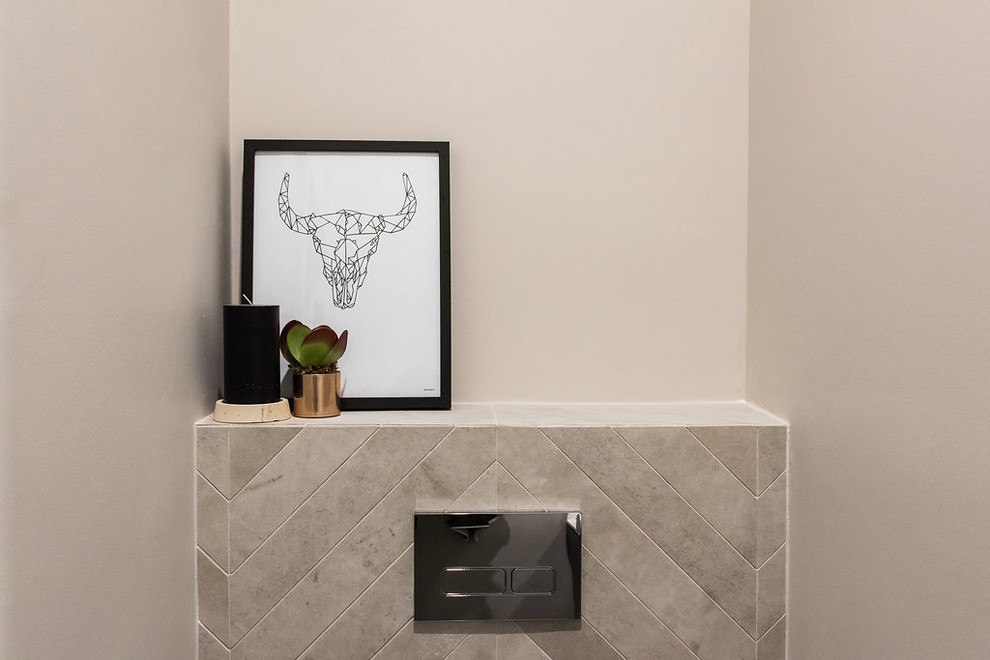 Design ideas for a small contemporary powder room in Melbourne with beaded inset cabinets, blue cabinets, a one-piece toilet, gray tile, porcelain tile, grey walls, medium hardwood floors, a vessel sink, engineered quartz benchtops and brown floor.
