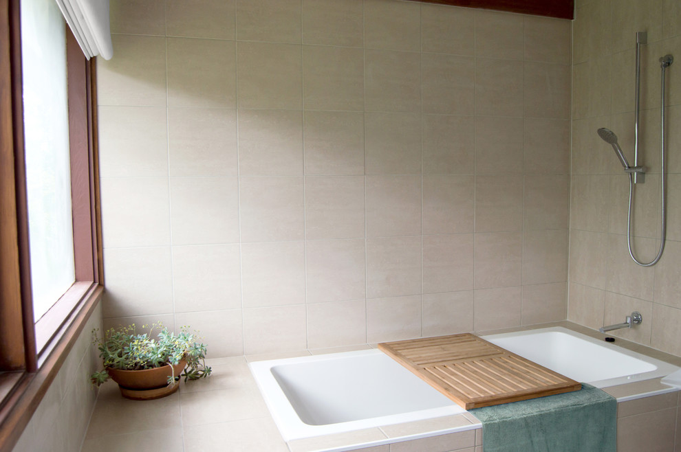 This is an example of a mid-sized midcentury bathroom in Canberra - Queanbeyan with a drop-in tub, a shower/bathtub combo, beige tile, porcelain tile and ceramic floors.