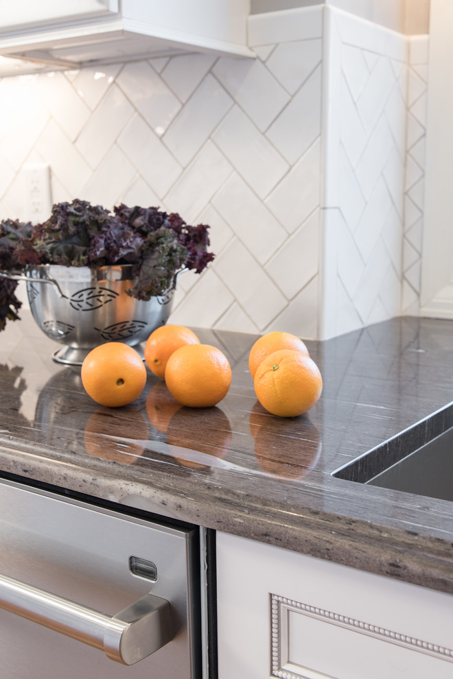 Enclosed kitchen - transitional u-shaped medium tone wood floor enclosed kitchen idea in St Louis with an undermount sink, flat-panel cabinets, white cabinets, granite countertops, white backsplash, subway tile backsplash, stainless steel appliances and an island
