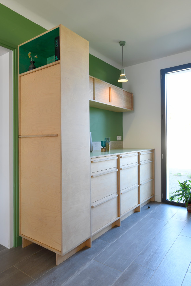 Diseño de cocina nórdica de tamaño medio abierta sin isla con puertas de armario de madera clara, encimera de laminado, salpicadero verde y encimeras verdes