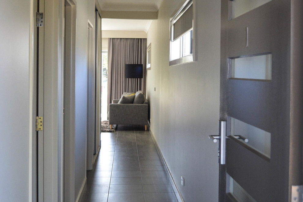 This is an example of a contemporary hallway in Other with beige walls, ceramic floors and grey floor.