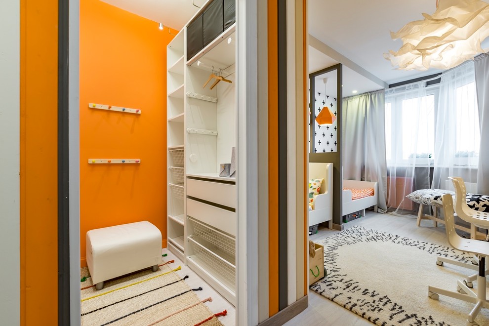 Design ideas for a scandinavian gender-neutral kids' room for kids 4-10 years old in Moscow with orange walls, light hardwood floors and grey floor.