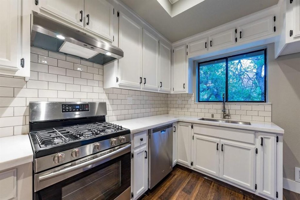 Inspiration for a small transitional l-shaped medium tone wood floor and brown floor enclosed kitchen remodel with an undermount sink, shaker cabinets, white cabinets, quartz countertops, white backsplash, subway tile backsplash, stainless steel appliances and no island