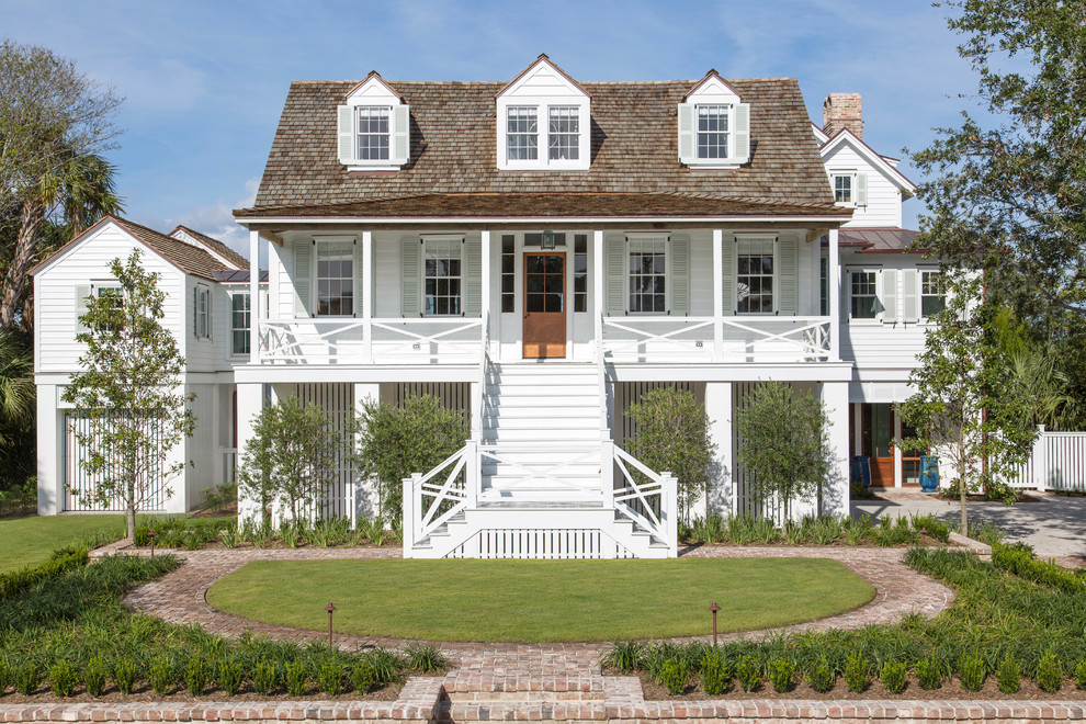 Design ideas for a beach style three-storey white exterior in Charleston with wood siding.