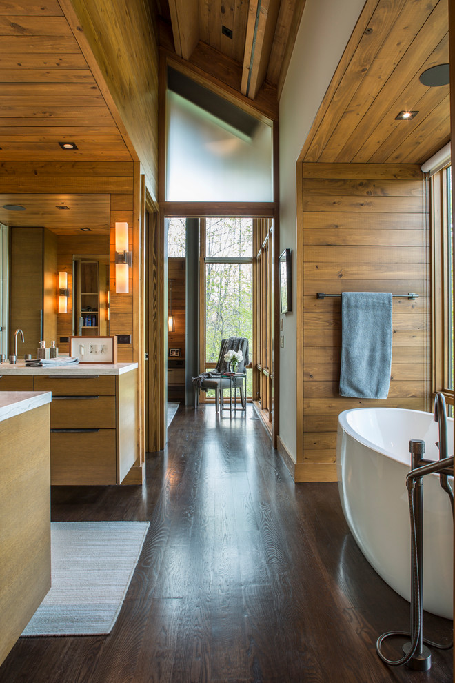 Inspiration for a large modern master bathroom in Charlotte with light wood cabinets, flat-panel cabinets, a freestanding tub, brown walls, dark hardwood floors, a drop-in sink, granite benchtops, brown floor and beige benchtops.