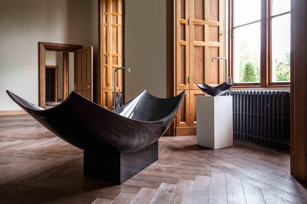 Großes Industrial Badezimmer En Suite mit freistehender Badewanne und dunklem Holzboden in Köln