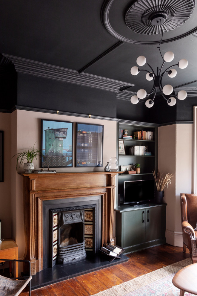 Cette image montre un salon bohème de taille moyenne et fermé avec parquet peint, une cheminée standard, un manteau de cheminée en carrelage, un téléviseur indépendant, un sol marron et du lambris.