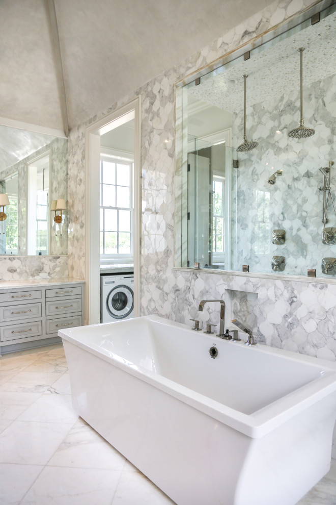Design ideas for an expansive transitional master bathroom in New Orleans with white cabinets, a freestanding tub, an open shower, gray tile, white walls, an undermount sink, white floor, white benchtops, a laundry, a double vanity, a built-in vanity and vaulted.