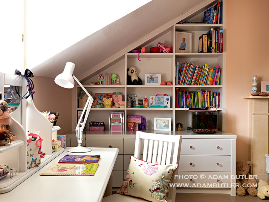 Design ideas for a mid-sized traditional kids' bedroom for kids 4-10 years old and girls in London with medium hardwood floors and pink walls.