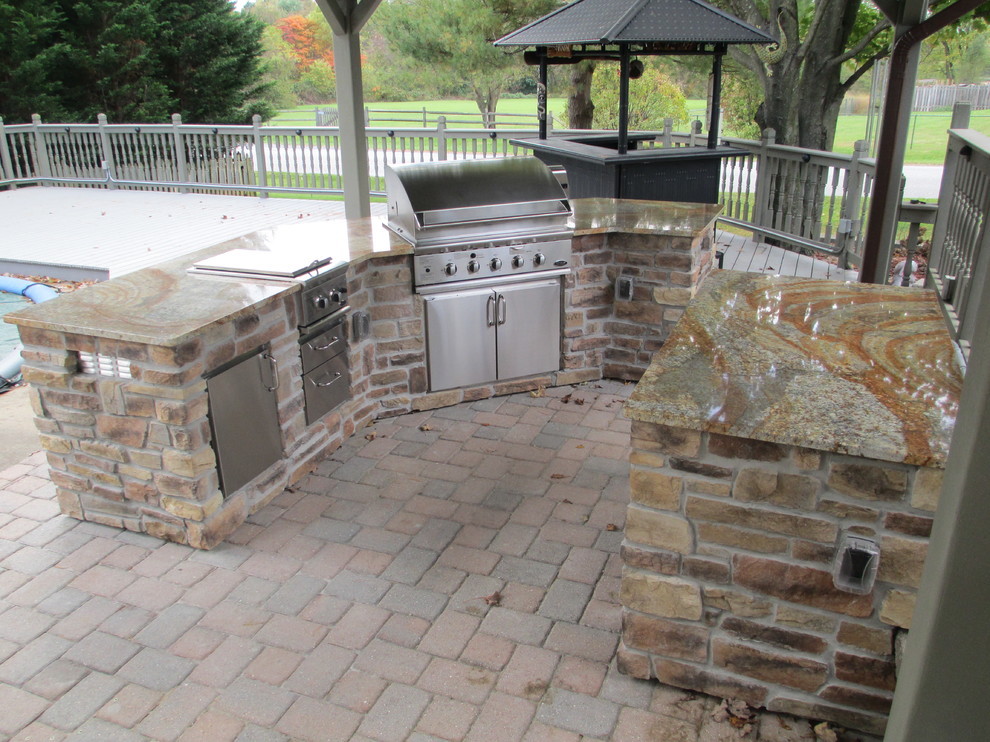 Inspiration for a mid-sized transitional backyard patio in DC Metro with an outdoor kitchen, brick pavers and a pergola.