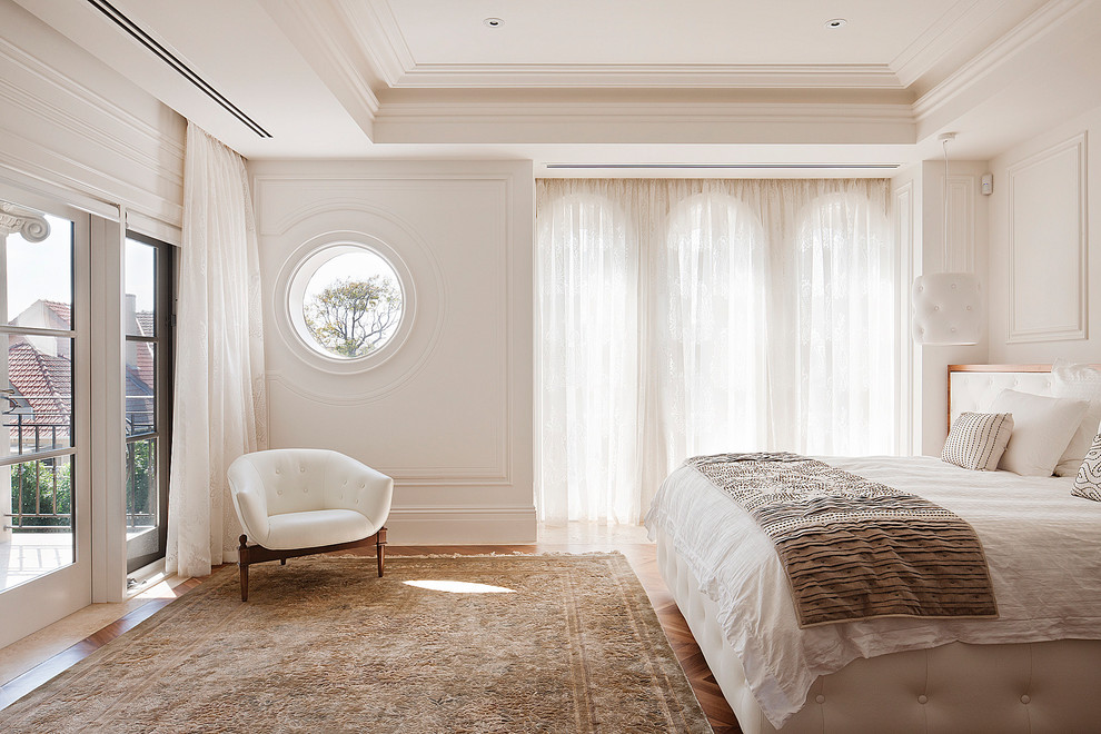This is an example of a transitional bedroom in Melbourne with white walls.