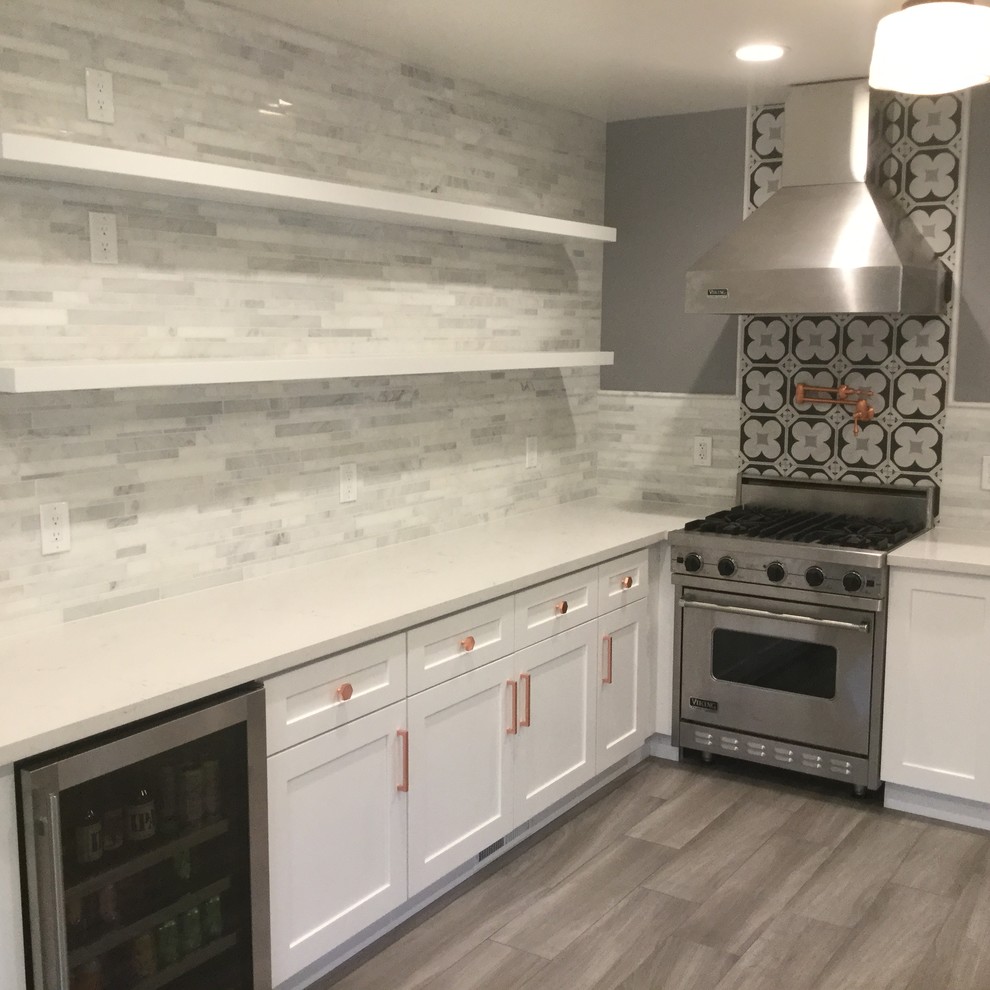 This is an example of a mid-sized transitional galley separate kitchen in San Francisco with a double-bowl sink, shaker cabinets, white cabinets, solid surface benchtops, grey splashback, stone tile splashback, dark hardwood floors and no island.
