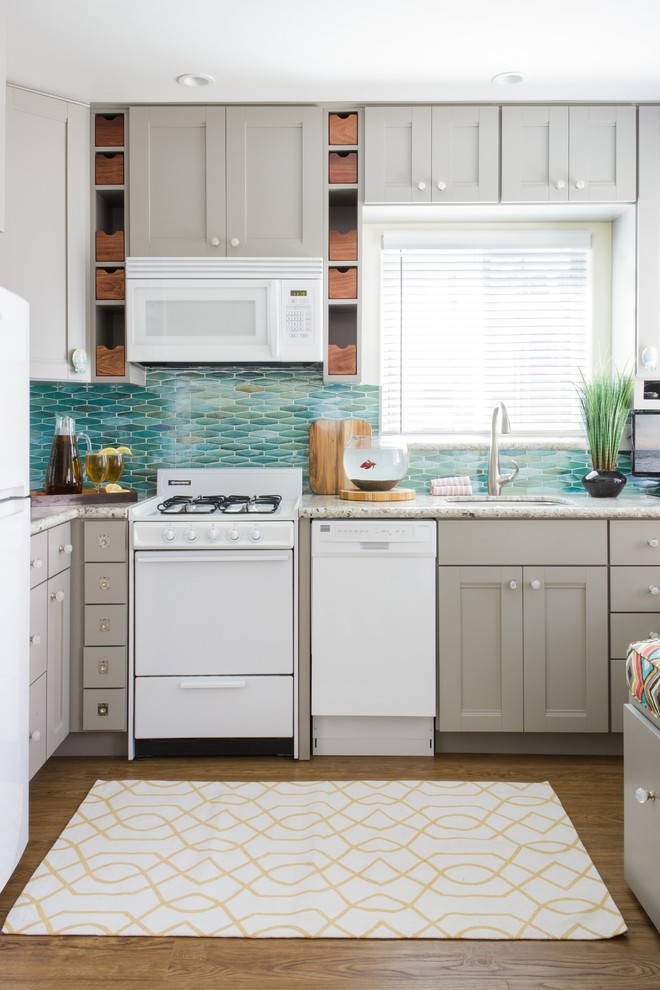 Design ideas for a small beach style l-shaped eat-in kitchen in San Diego with an undermount sink, shaker cabinets, grey cabinets, granite benchtops, blue splashback, white appliances, vinyl floors, glass tile splashback, brown floor and grey benchtop.