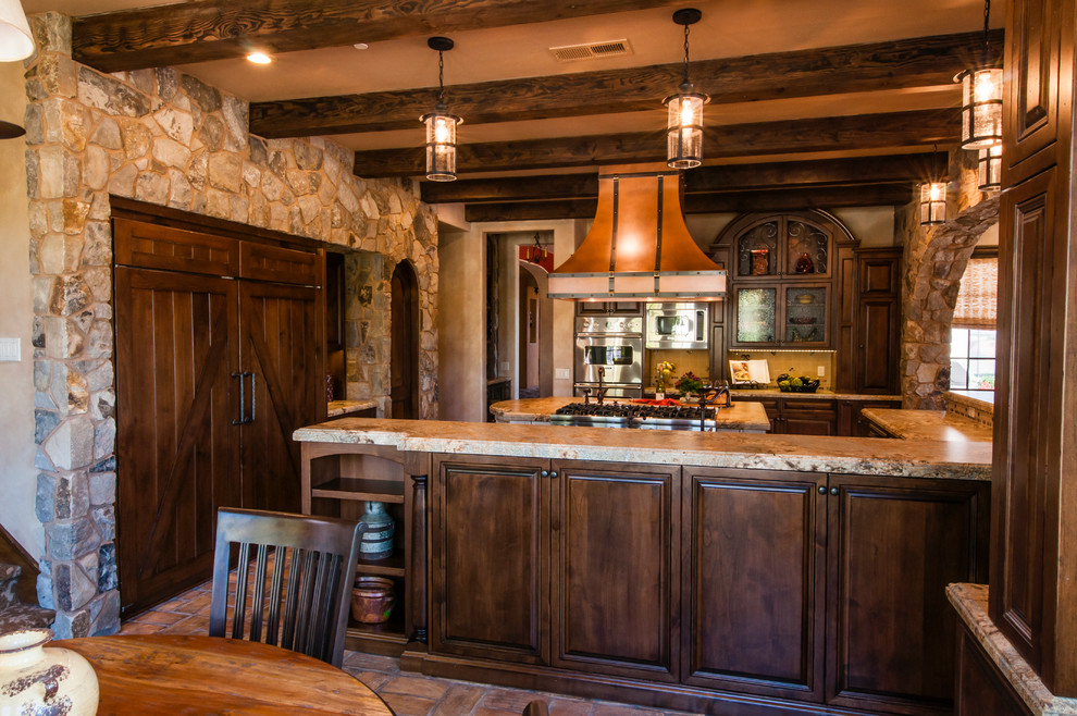 Arts and crafts l-shaped eat-in kitchen in San Diego with recessed-panel cabinets, dark wood cabinets, granite benchtops, panelled appliances, terra-cotta floors and with island.