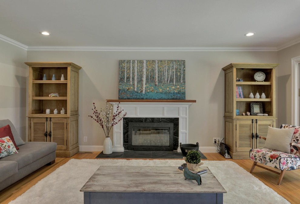 This is an example of a mid-sized country formal open concept living room in San Francisco with beige walls, light hardwood floors, a standard fireplace, a stone fireplace surround and no tv.