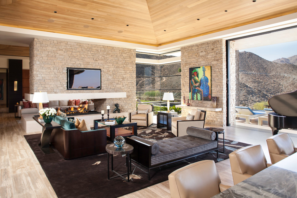 Photo of a large contemporary open concept living room in San Diego with a two-sided fireplace, a music area, a wall-mounted tv and travertine floors.
