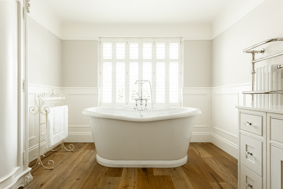 Inspiration for a traditional bathroom in Dorset with shaker cabinets, beige cabinets, a freestanding tub, a curbless shower, gray tile, mosaic tile, grey walls, medium hardwood floors, marble benchtops, an open shower and white benchtops.
