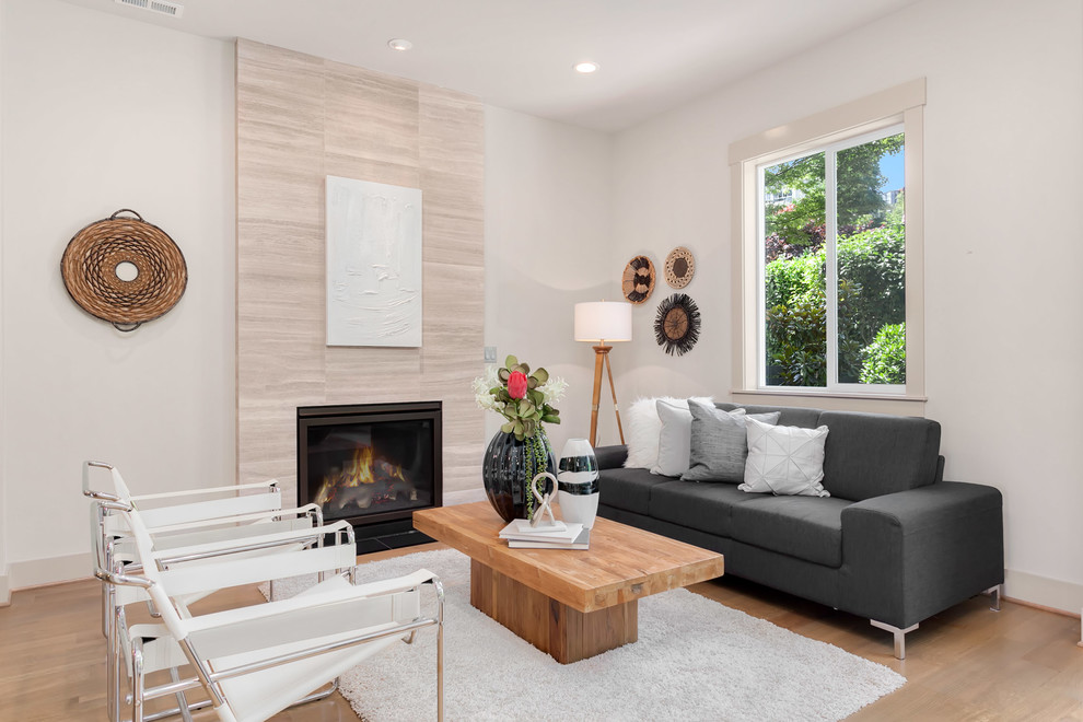 Living room - large modern open concept medium tone wood floor living room idea in Seattle with beige walls, a standard fireplace and a metal fireplace