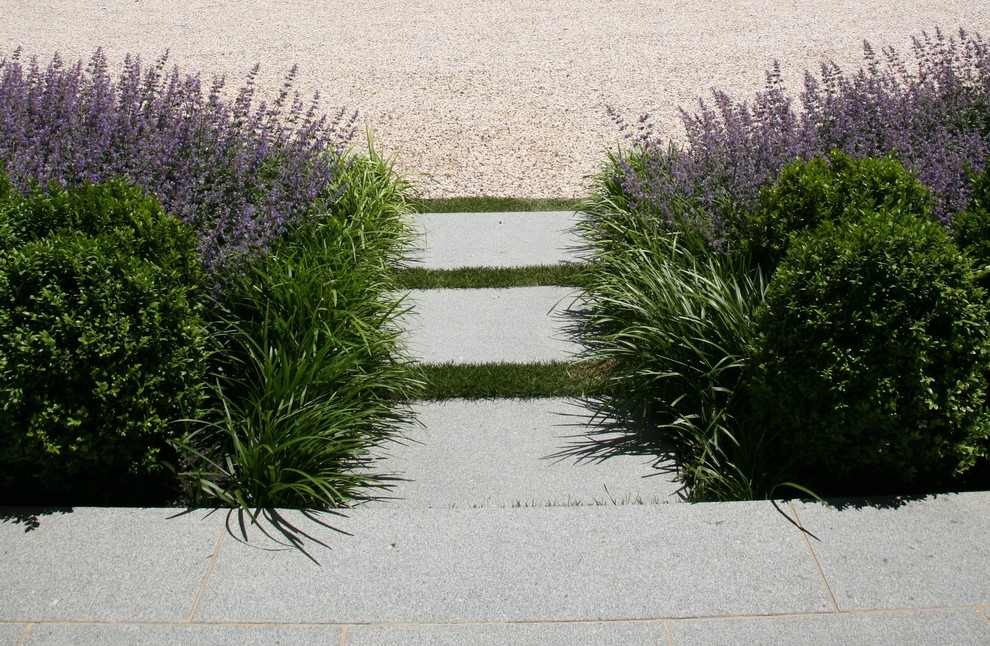Design ideas for a beach style front yard formal garden in New York with natural stone pavers.