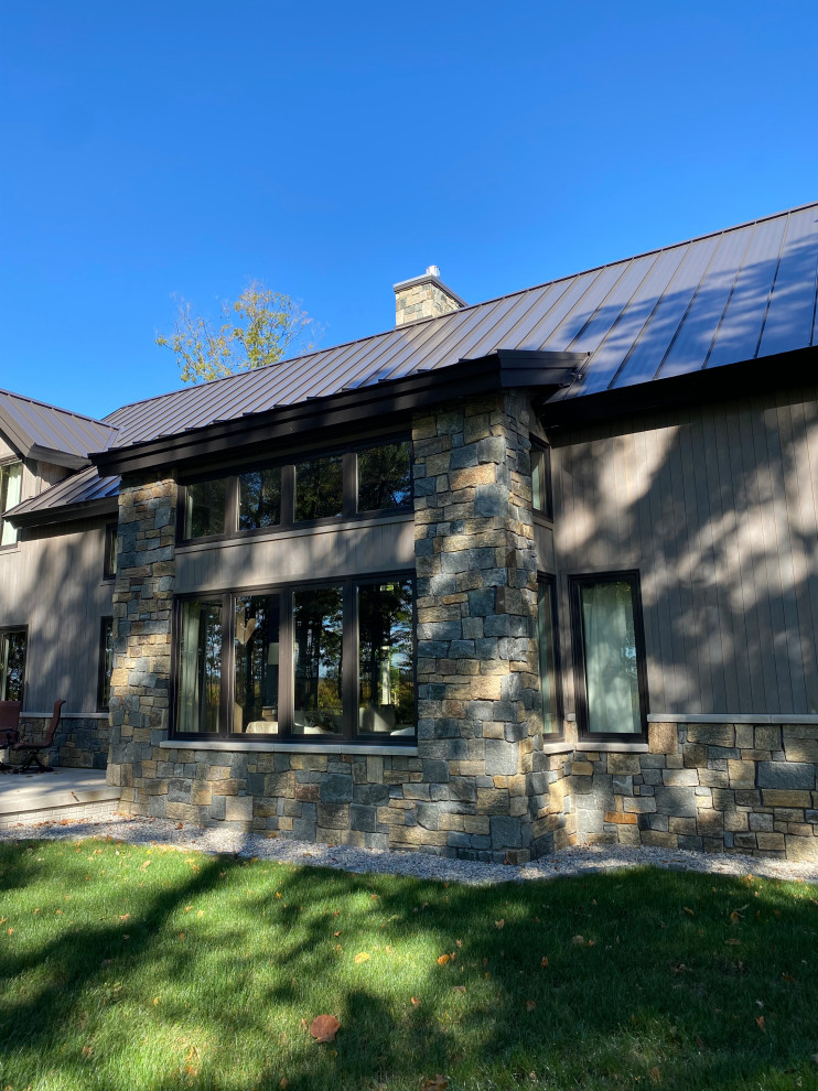 Inspiration for a rustic gray three-story wood gable roof remodel with a metal roof and a brown roof