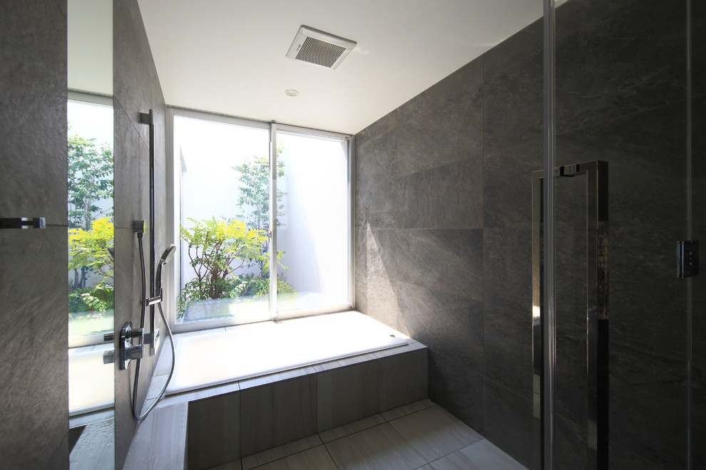 Small modern master bathroom in Other with an alcove tub, gray tile and grey walls.