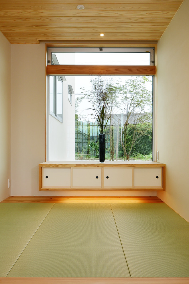 Diseño de hall grande con paredes blancas, tatami, puerta corredera, puerta de madera en tonos medios, suelo verde, madera y papel pintado