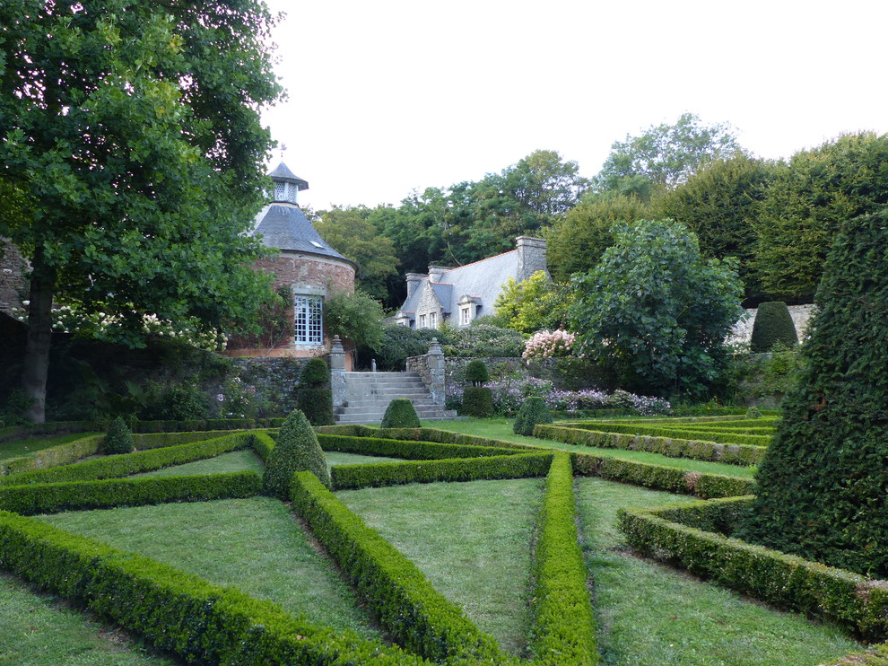 Expansive traditional courtyard partial sun formal garden in Toulouse with a garden path for summer.