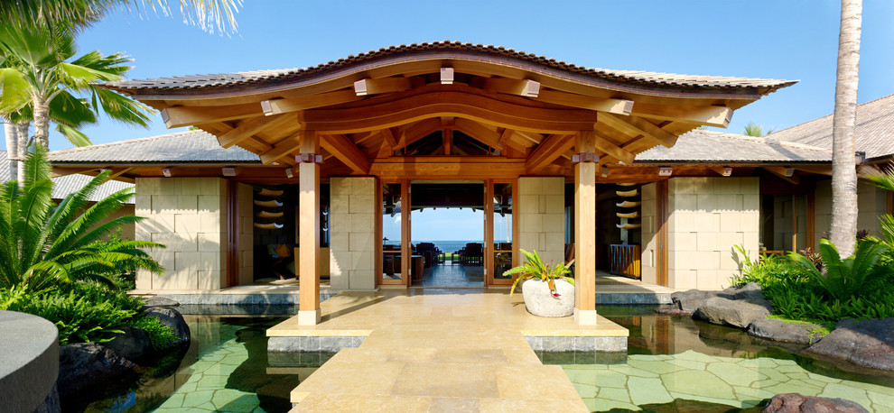 Tropical entryway in Hawaii with a double front door and a glass front door.