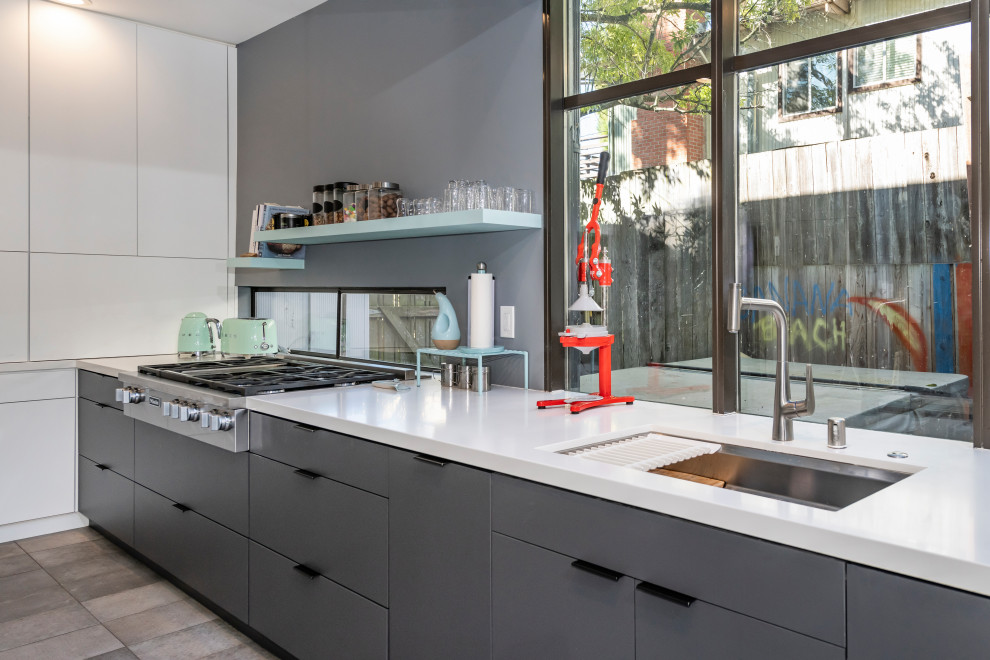 Photo of a mid-sized modern l-shaped kitchen pantry in San Francisco with a single-bowl sink, flat-panel cabinets, grey cabinets, quartz benchtops, white splashback, engineered quartz splashback, stainless steel appliances, ceramic floors, grey floor and white benchtop.