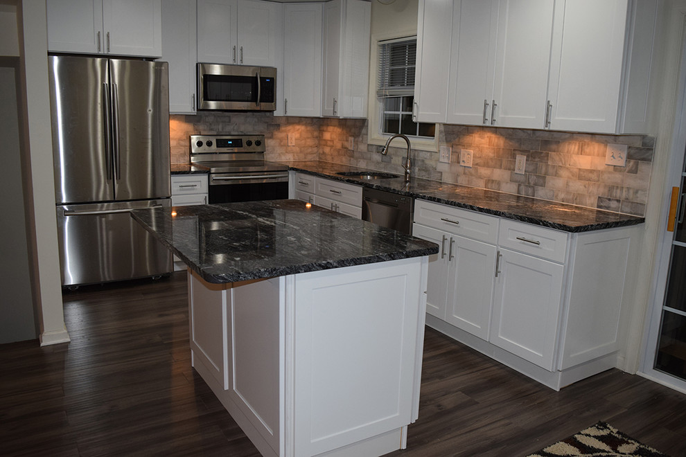 Design ideas for a mid-sized contemporary l-shaped eat-in kitchen in DC Metro with an undermount sink, shaker cabinets, white cabinets, granite benchtops, white splashback, subway tile splashback, stainless steel appliances, laminate floors, with island and brown floor.