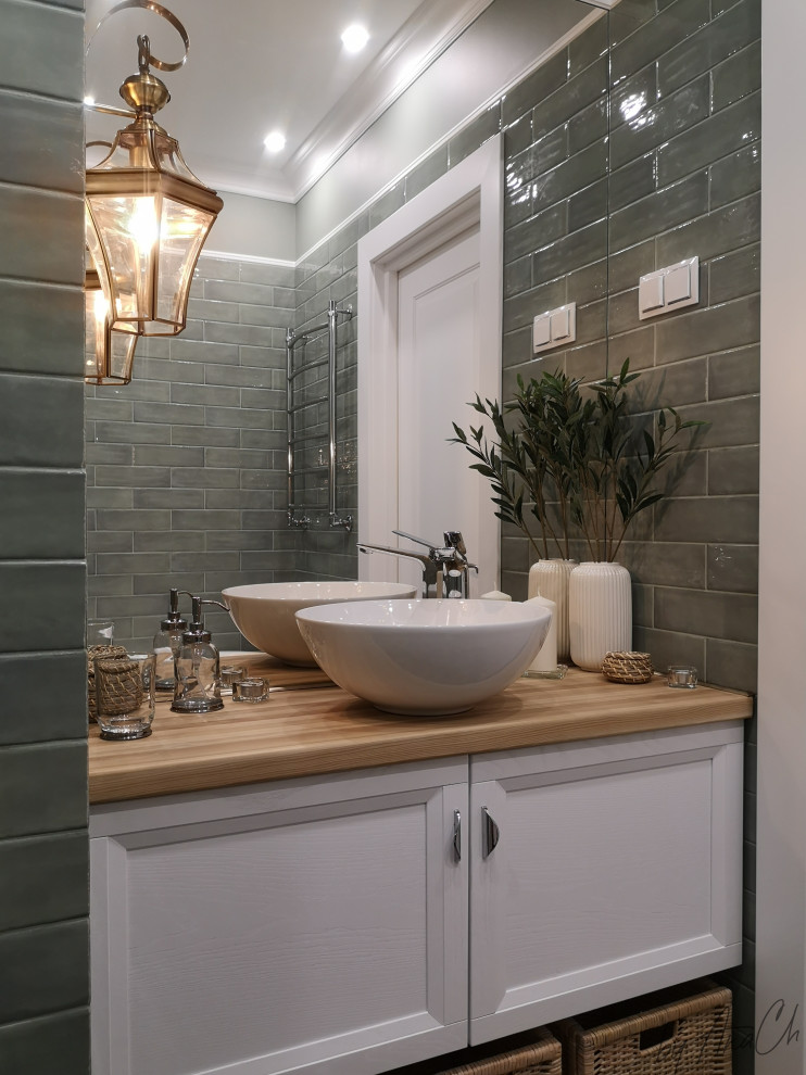 Medelhavsstil inredning av ett mellanstort beige beige en-suite badrum, med luckor med infälld panel, vita skåp, ett badkar med tassar, en dusch/badkar-kombination, grön kakel, keramikplattor, gröna väggar, klinkergolv i porslin, ett nedsänkt handfat, träbänkskiva, grönt golv och dusch med duschdraperi