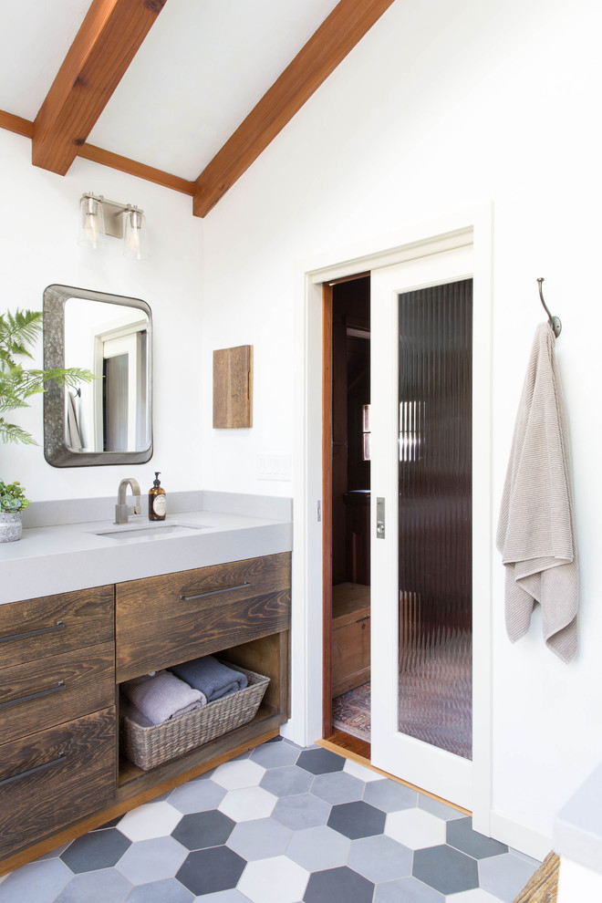 Example of a transitional gray floor bathroom design with flat-panel cabinets, dark wood cabinets, white walls, an undermount sink, gray countertops and quartz countertops
