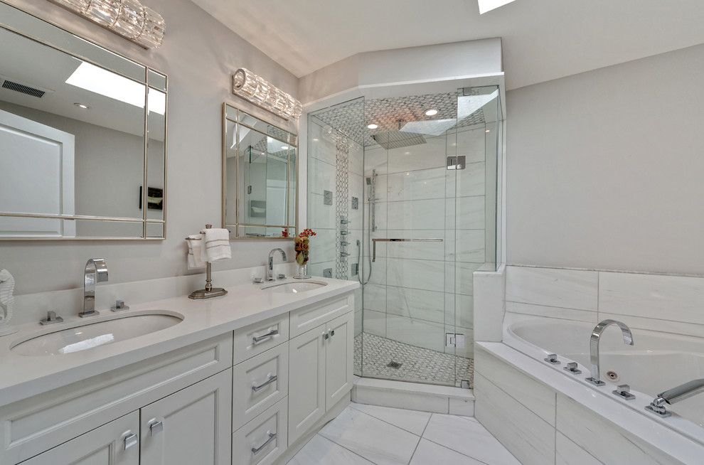 Photo of a large transitional master bathroom in Toronto with shaker cabinets, white cabinets, a corner tub, a corner shower, white tile, porcelain tile, white walls, porcelain floors, an undermount sink, engineered quartz benchtops, white floor and a hinged shower door.