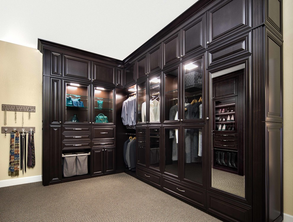 Photo of a large traditional gender-neutral walk-in wardrobe in San Francisco with raised-panel cabinets, dark wood cabinets, carpet and multi-coloured floor.