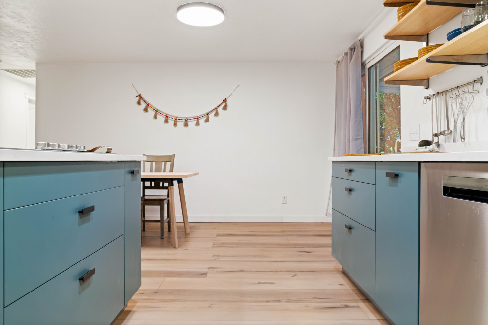 Inspiration for a small eclectic l-shaped separate kitchen in Seattle with a drop-in sink, flat-panel cabinets, blue cabinets, marble benchtops, white splashback, coloured appliances, vinyl floors, with island, beige floor and white benchtop.