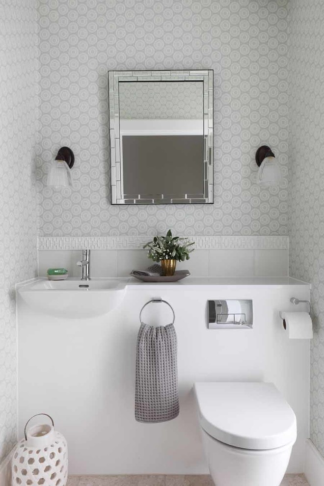 Inspiration for a small transitional powder room in London with a wall-mount sink, grey walls and a wall-mount toilet.