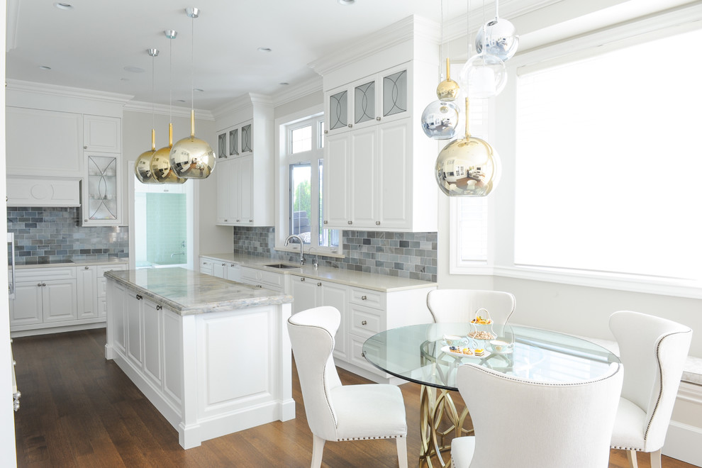 Inspiration for a mid-sized transitional u-shaped light wood floor eat-in kitchen remodel in Vancouver with an undermount sink, raised-panel cabinets, white cabinets, blue backsplash, stainless steel appliances and an island