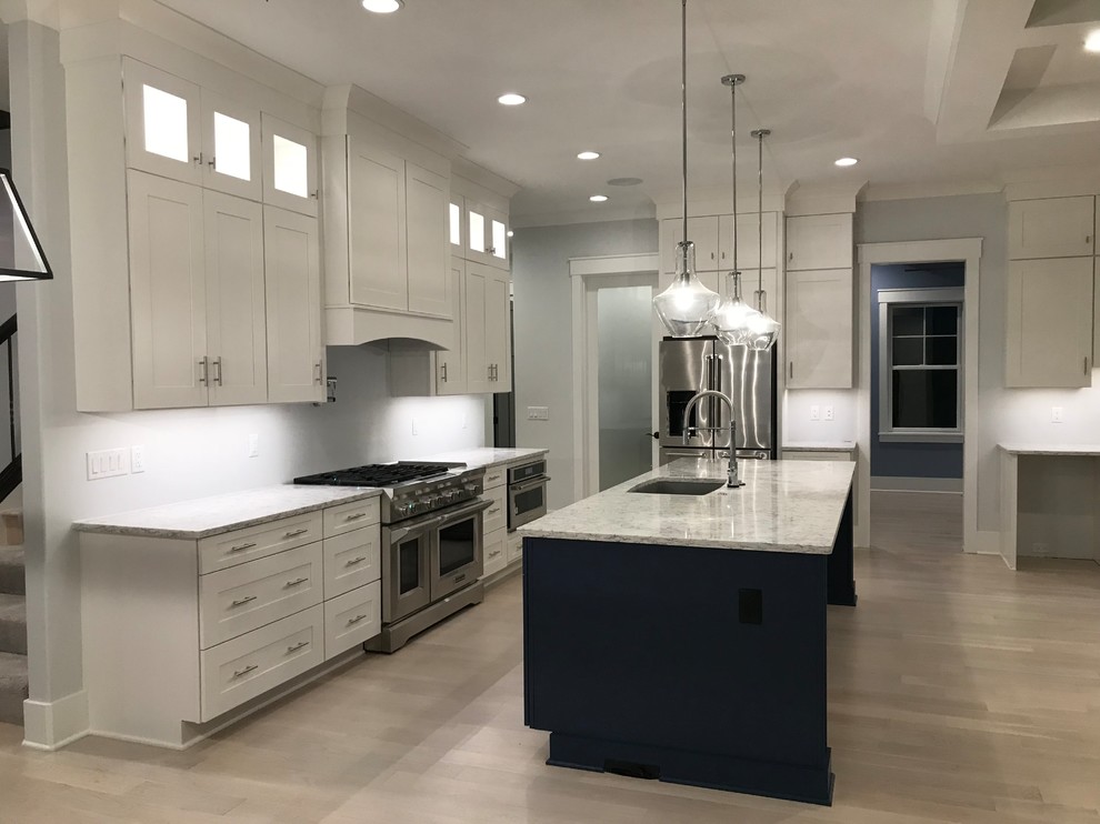 Open concept kitchen - mid-sized transitional l-shaped light wood floor and beige floor open concept kitchen idea in Cincinnati with an undermount sink, shaker cabinets, white cabinets, granite countertops, stainless steel appliances, an island and gray countertops