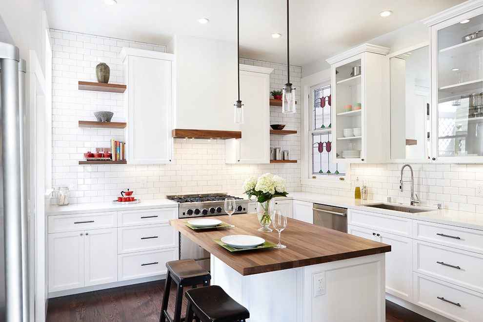 Mid-sized traditional l-shaped kitchen in San Francisco with a single-bowl sink, recessed-panel cabinets, white cabinets, quartz benchtops, white splashback, subway tile splashback, stainless steel appliances, dark hardwood floors and with island.