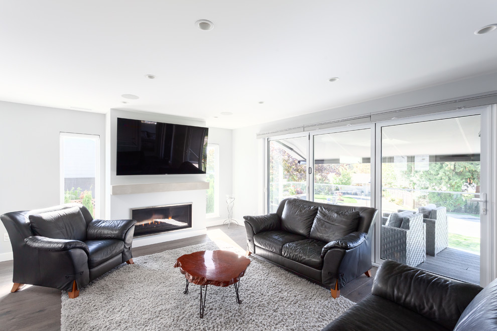 Inspiration for a mid-sized contemporary enclosed family room in Vancouver with white walls, dark hardwood floors, a ribbon fireplace, a concrete fireplace surround, a wall-mounted tv and brown floor.